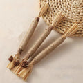 Drei Molar-Beißstäbe mit Naturfaser-Wicklung und Raffia-Quasten in Nahaufnahme